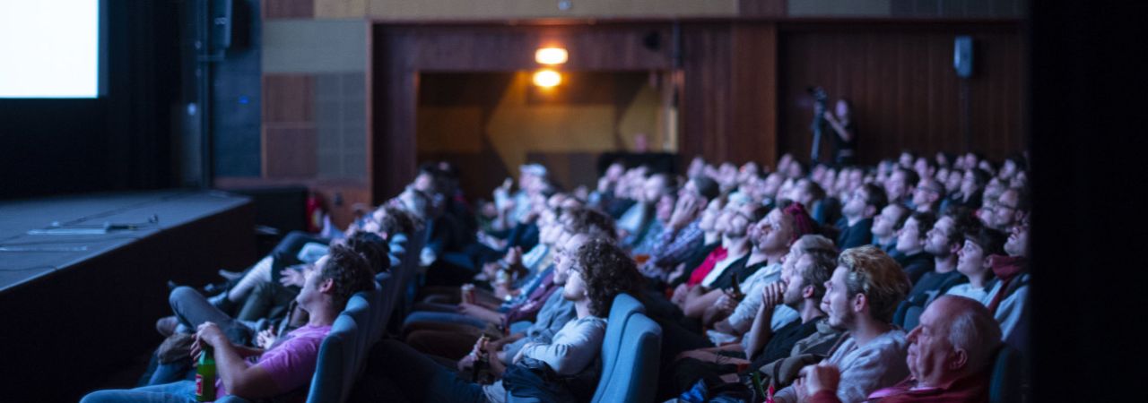 Zuschauer*innen im Kino, von der Seite fotografiert